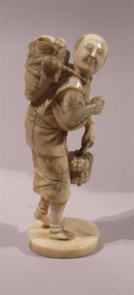 null OKIMONO en ivoire finement sculpté et à belle patine d'un paysan la tête levée...