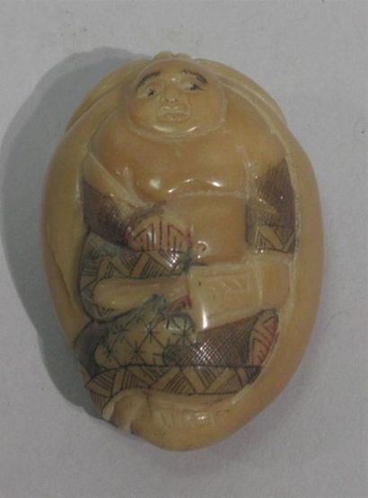 null NETSUKE en noix de corozo ou résine représentant un personnage torse nu à l'évantail.
Haut....