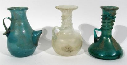 null Trois vases en verre, l'un de couleur blanche, les autres de couleur verte et...