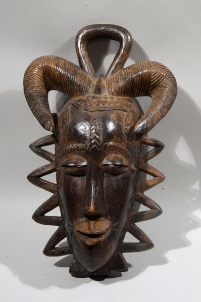 null MASK in carved wood representing a face with ram's horns.
Gouro work, Ivory...
