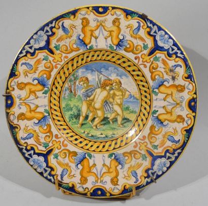 null ROUND PLATE in polychrome earthenware with decoration of three putti carrying...