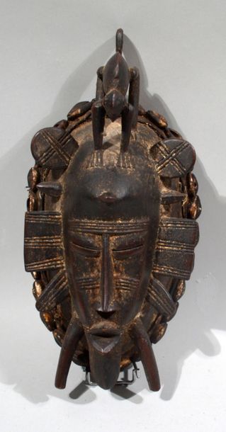 null Wooden MASK with cauri inlays representing a face surmounted by a chameleon.
Senoufo...