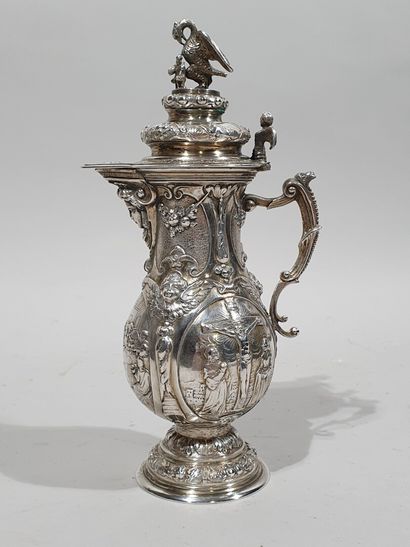 null A solid silver covered ewer resting on a round foot with repoussé decoration...