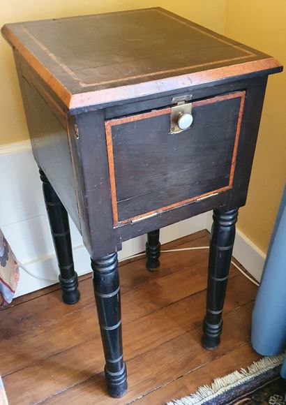 null NIGHT TABLE in partially blackened pearwood opening by a door in front and resting...