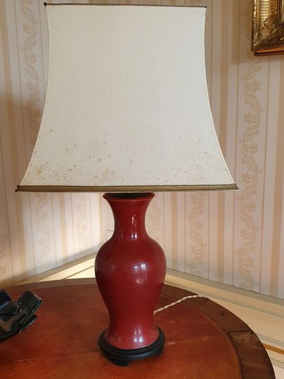 null Pair of oxblood red earthenware LAMPS resting on a blackened wooden base - The...