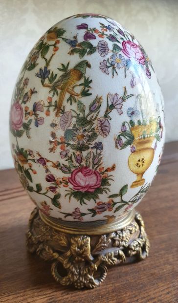 null A stoneware EGG decorated with parrots on flowery foliage

It rests on a gilt...