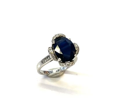 null Four-lobed ring in 18 K (750/oo) white gold centered on an oval-cut sapphire,...