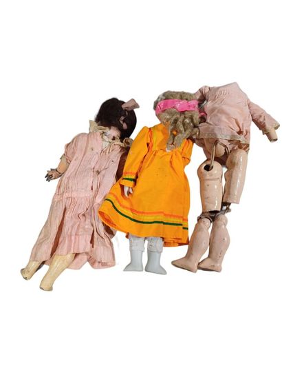 null Lot de trois poupées dont deux à têtes en porcelaine, une sans tête.
(usures...