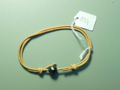 null Bracelet de cuir beige agrémenté d'une perle de Tahiti. 