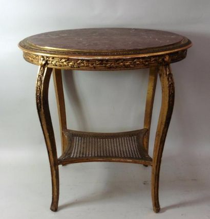 null Table ovale de salon en bois stuqué, doré et sculpté, reposant sur quatre reliés...