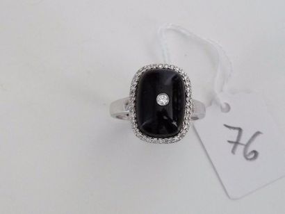 null Bague en or gris 18K (750/oo) centrée d'un cabochon d'onyx repercé d'un diamant...