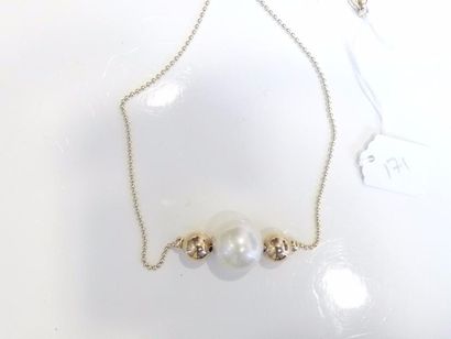 null Collier de petites boules d'or jaune 14K (585/oo) orné au centre d'une perle...