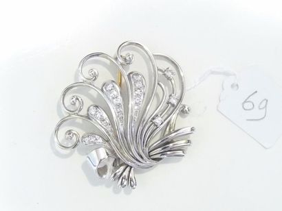 null Broche en or gris à décor de volutes ornée de lignes de diamants, vers 1960....