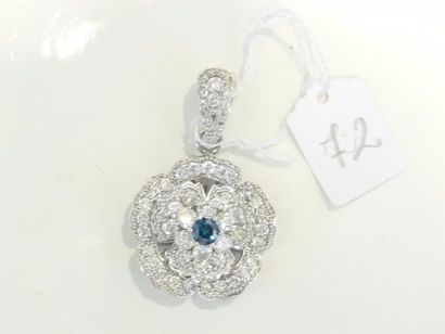 null Pendentif en or gris 14K (585/oo) à décor floral centré d'un diamant bleu taille...