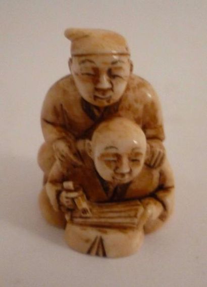 null Netsuke en ivoire bien sculpté d'un artisan et son fils fabriquant une ombrelle...