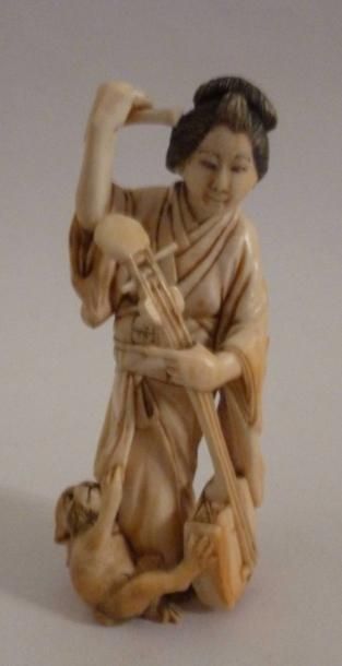 null Okimono en ivoire très finement sculpté d'une jeune femme jouant du shamisen,...
