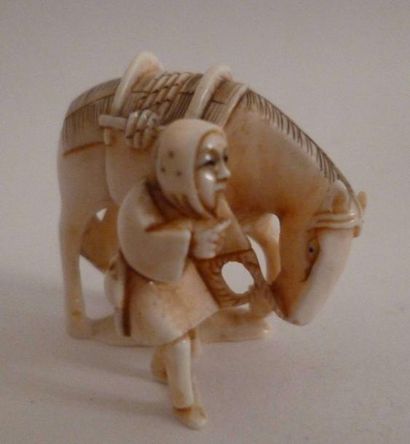 null Netsuke en ivoire finement sculpté d'un palefrenier tenant un cheval par la...