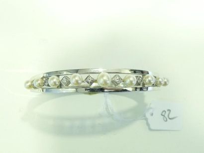 Bracelet jonc rigide ouvrant en or gris 18K (750/oo) ajouré agrémenté de perles de...