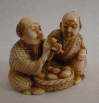 null Netsuké en ivoire finement sculpté de deux paysans assis devant un panier d'oeufs...