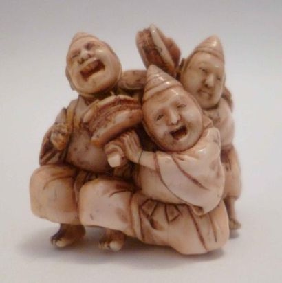 null Superbe netsuké en ivoire finement sculpté de trois enfants jouant du tambourin...