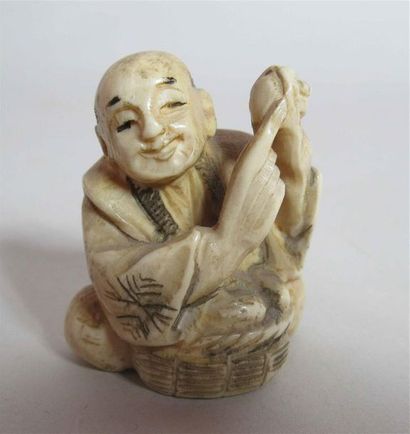 null Netsuke en ivoire bien sculpté d'un souriant paysan assis devant un panier et...