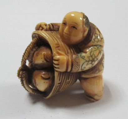 null Netsuke en ivoire à trace de polychromie sculpté d'un pêcheur montrant un panier...