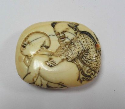 null Manju en ivoire de forme ovale arrondi sculpté en léger relief d'un Karako jouant...