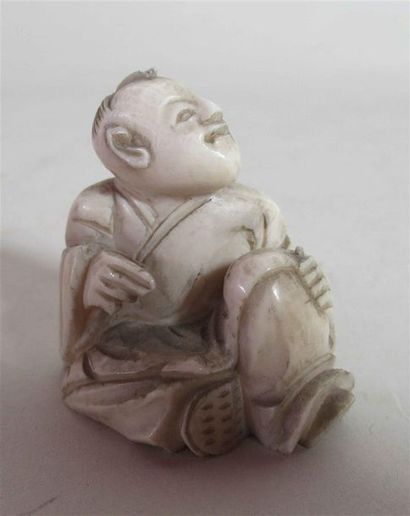 null Netsuke en ivoire bien sculpté d'un Karako assis la main posée sur un genou...
