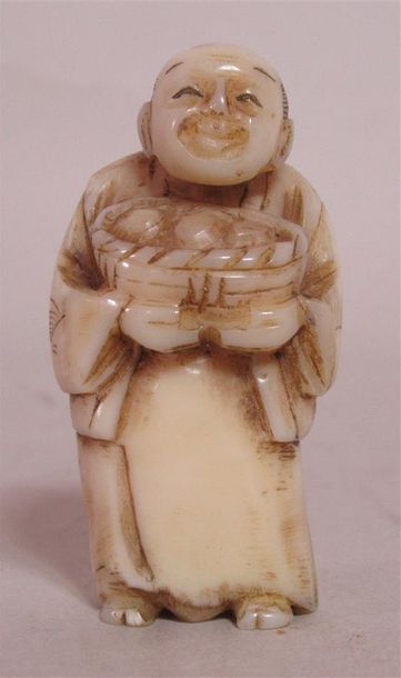 null Netsuke en ivoire sculpté d'un souriant paysan tenant un panier de fruits -...