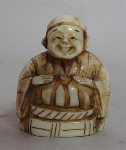 null Netsuke en ivoire sculpté d'un paysan mettant une citrouille dans un panier...