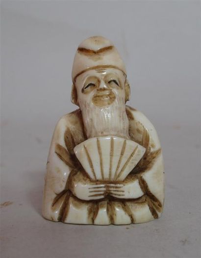 null Netsuke en ivoire sculpté d'un souriant sage assis tenant un éventail - Signé...