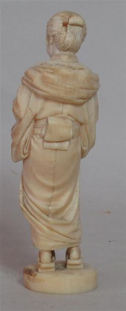 null Okimono en ivoire finement sculpté d'une femme vêtue d'un kimono d'apparat et...