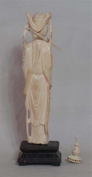 null Statuette en ivoire sculptée d'une jeune femme à la coiffe aux rubans tenant...