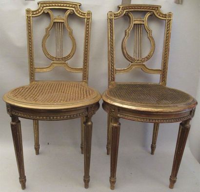 null Paire de chaises en bois doré et stuqué, assises cannées, les dossiers à décor...