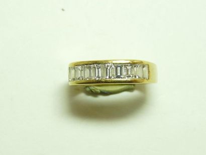 null Bague en or jaune 18K (750/oo) centrée d'une ligne de diamants taille baguette...