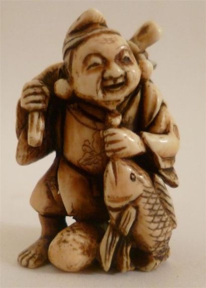 Netsuke en ivoire finement sculpté d'un souriant pêcheur tenant fièrement sa prise,...