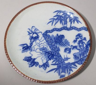 CHINE - Assiette à décor en bleu sous couverte de feuilles de bambous et d'un paysage....