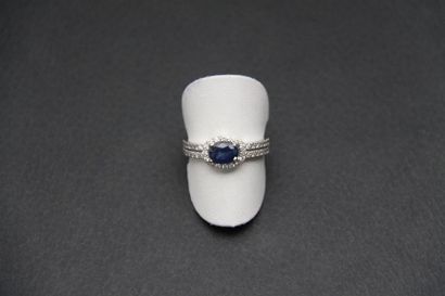 null Bague en or gris 18K (750/oo) centrée d'un saphir ovale dans un entourage et...