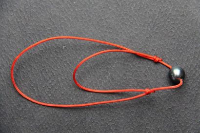 null Bracelet de cordonnet rouge extensible agrémenté d'une perle de Tahiti.