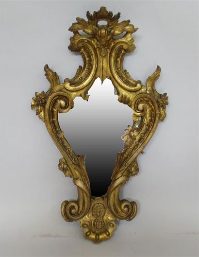 null Miroir, le cadre en bois sculpté et doré à décor de feuillage et de volutes....