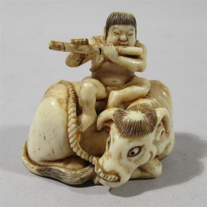 null Netsuke en ivoire finement sculpté d'un jeune arçon assis sur le dos d'un buffle...