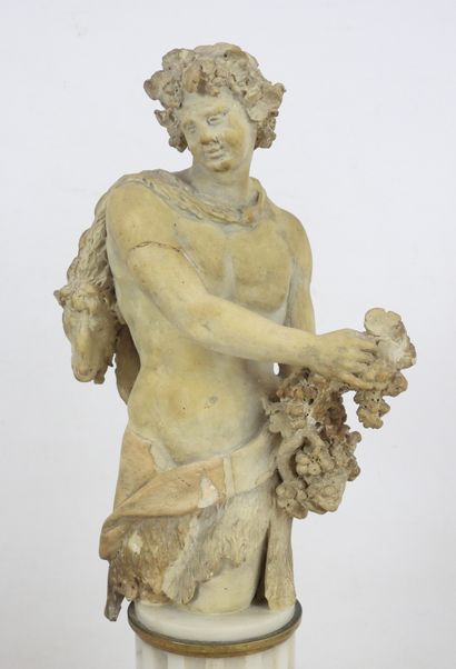 null A terracotta BACCHUS BUST resting on a marble base in the form of a fluted column,...