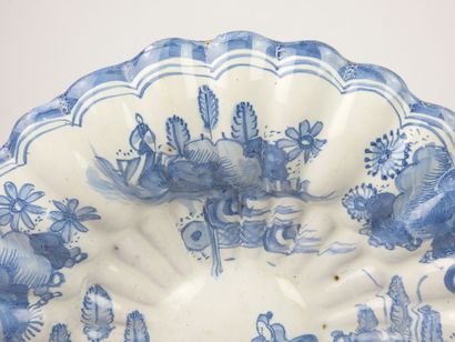 null DELFT : Ribbed earthenware dish decorated in blue camaieu with two Chinese....