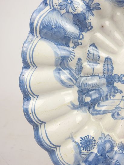 null DELFT : Ribbed earthenware dish decorated in blue camaieu with two Chinese....