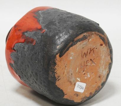 null Earthenware vase with a flattened belly with a red and black cover.

Marked...