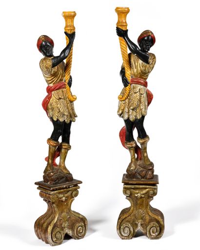 null PAIR OF NUBIENS in carved and polychromed wood supporting torches and resting...