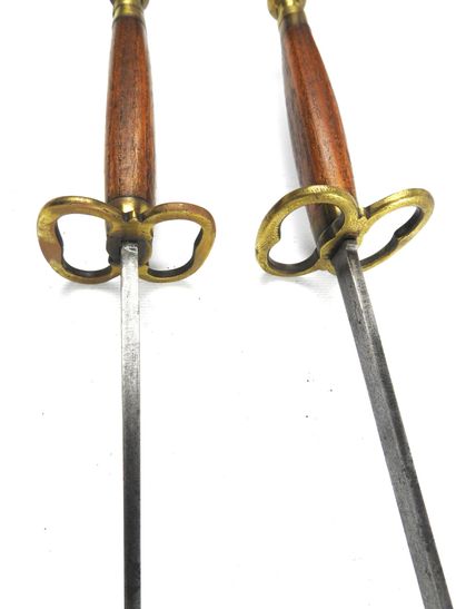null FENCING. Pair of foils with cigar-shaped wooden handles, spherical pommels and...