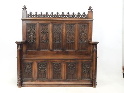 null Neo-Gothic style walnut bench with high straight back and heraldic decoration....
