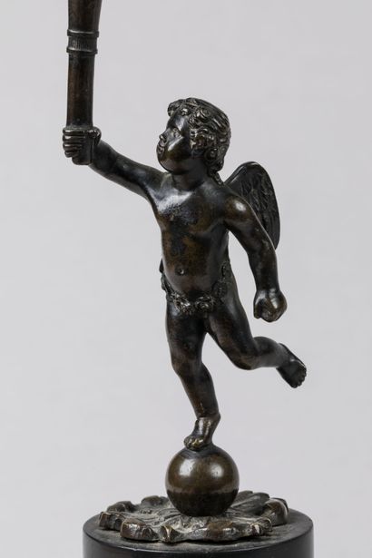 null STATUETTE en bronze patiné représentant un Angelot portant une torche surmontée...