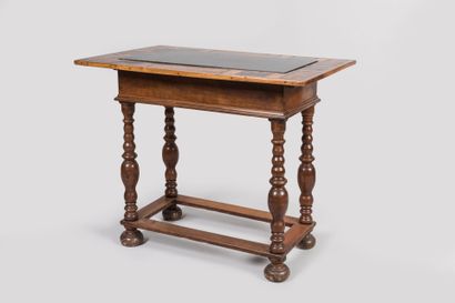 null Middle table in molded or turned walnut; the rectangular top with embedded slate...